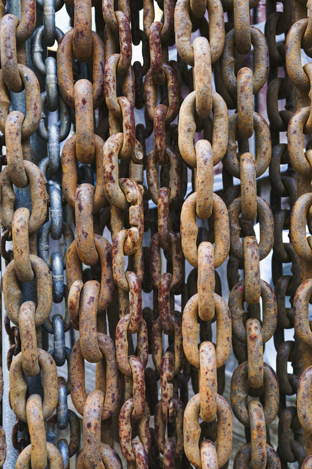 a bunch of rusted metal chains hanging from a ceiling