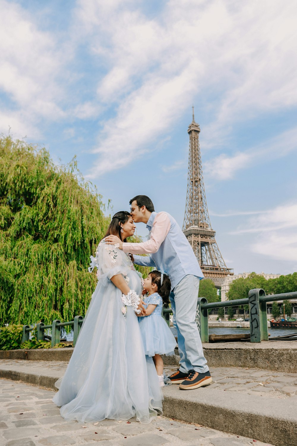 a man and woman kissing in front of the eiffel tower