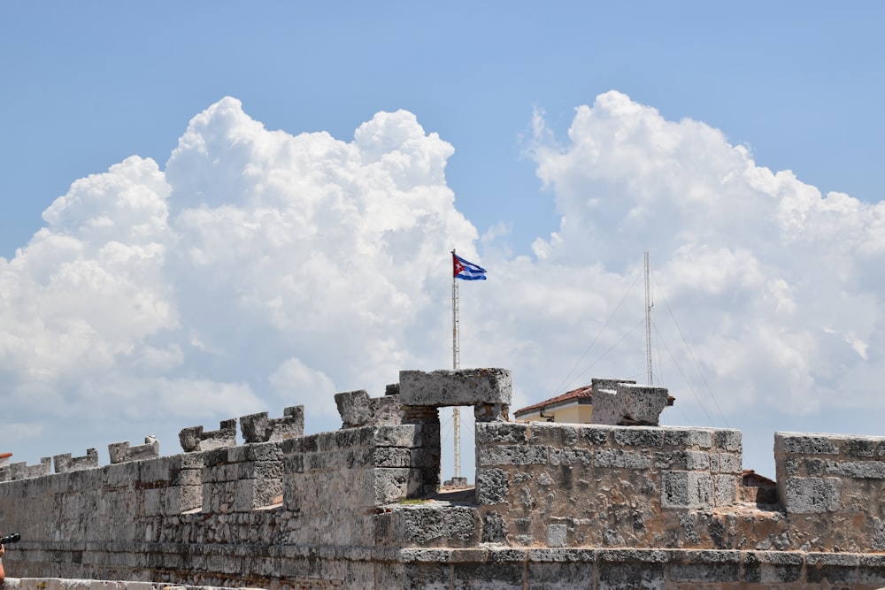 Una bandera ondeando sobre un muro de piedra