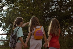 a group of young girls holding hands and walking