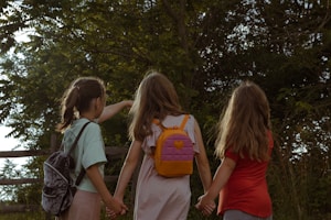 a group of young girls holding hands and walking