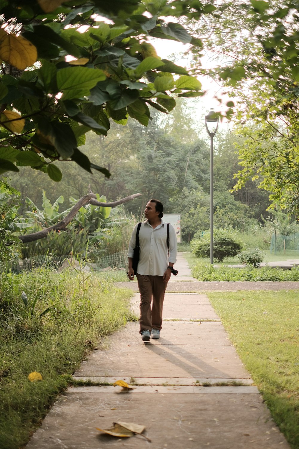 a woman walking down a path in a park
