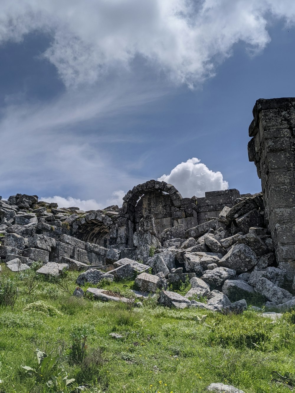 a large rock structure sitting on top of a lush green field