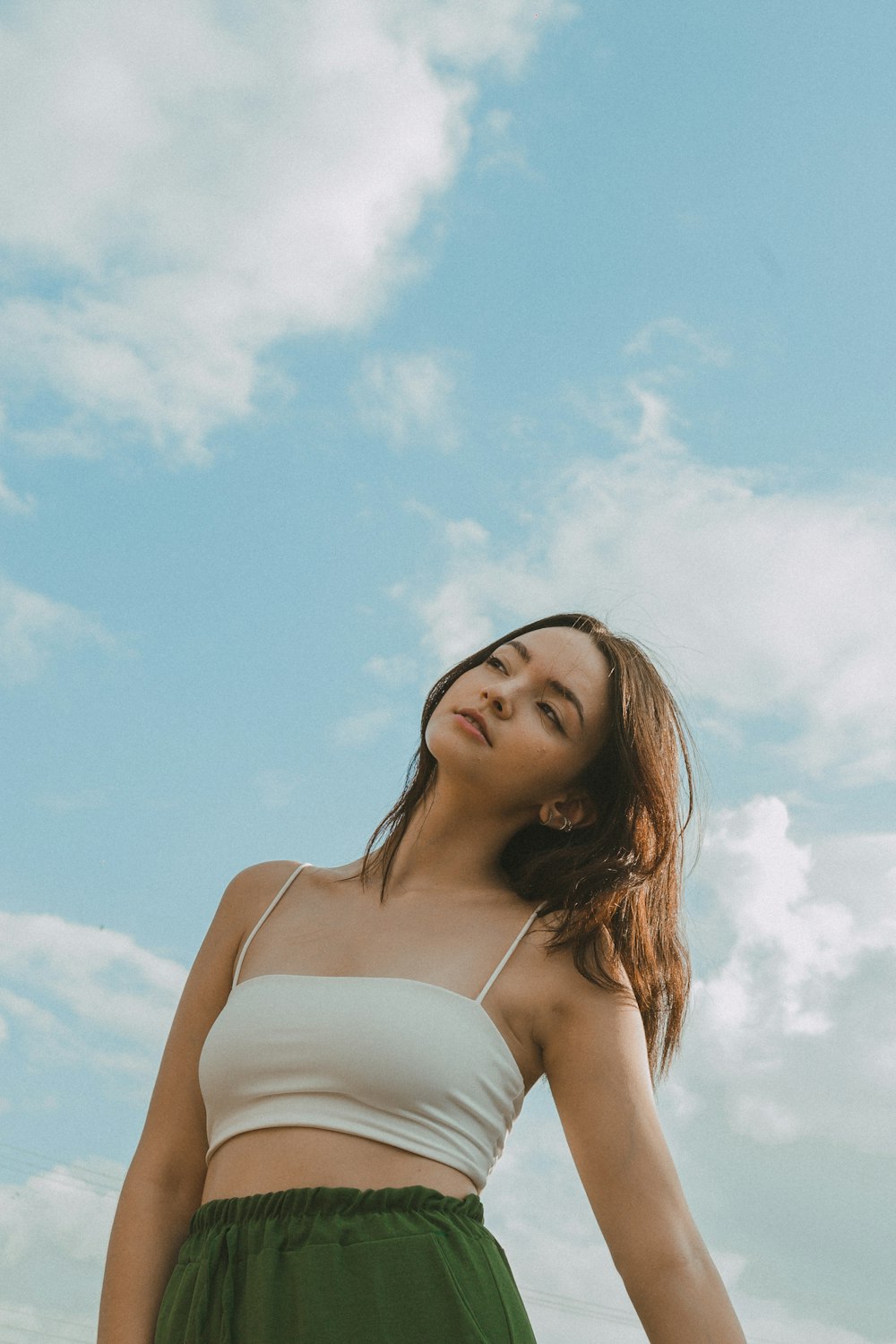 a woman in a white top and a green skirt