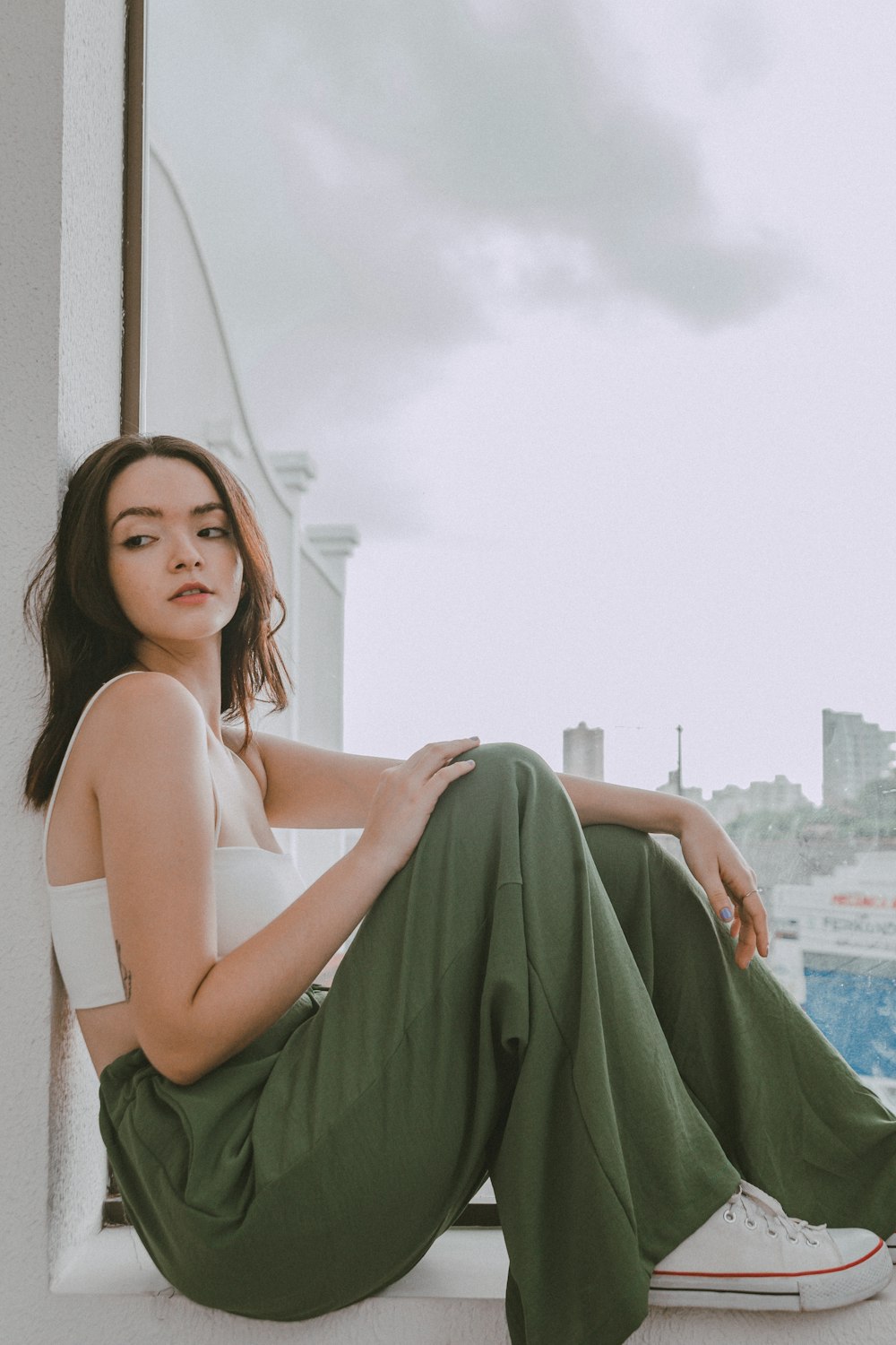 a woman sitting on a ledge with her legs crossed