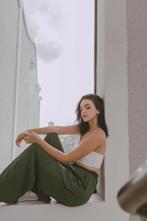A serene woman sitting barefoot on a wooden floor, sunlight gently illuminating her peaceful expression as she journals.