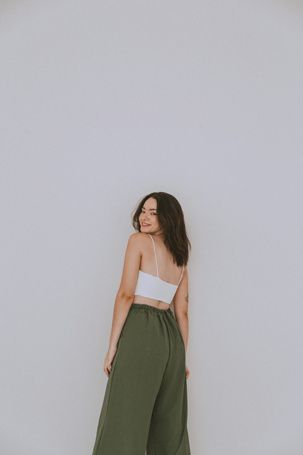 a woman standing in front of a white wall