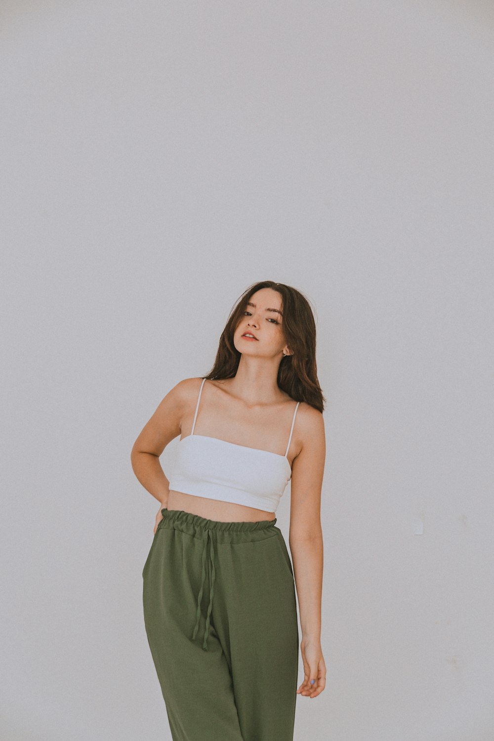 a woman standing in front of a white wall