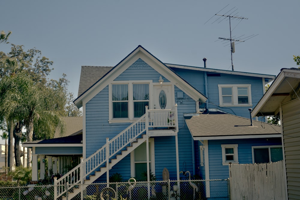 a blue house with a white porch and stairs