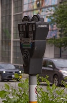 Close-up of a smart parking meter installed on a busy sidewalk.