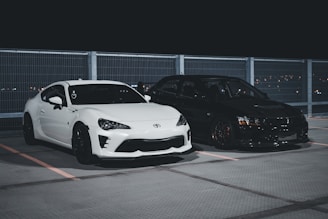 a couple of cars parked next to each other in a parking lot