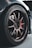 A close-up view of a car wheel with a detailed focus on the alloy rim and tire. The tire bears the brand name 'Potenza' and 'Bridgestone', and the wheel has a metallic finish with several spokes. The background is slightly blurred, highlighting the wheel as the focal point.