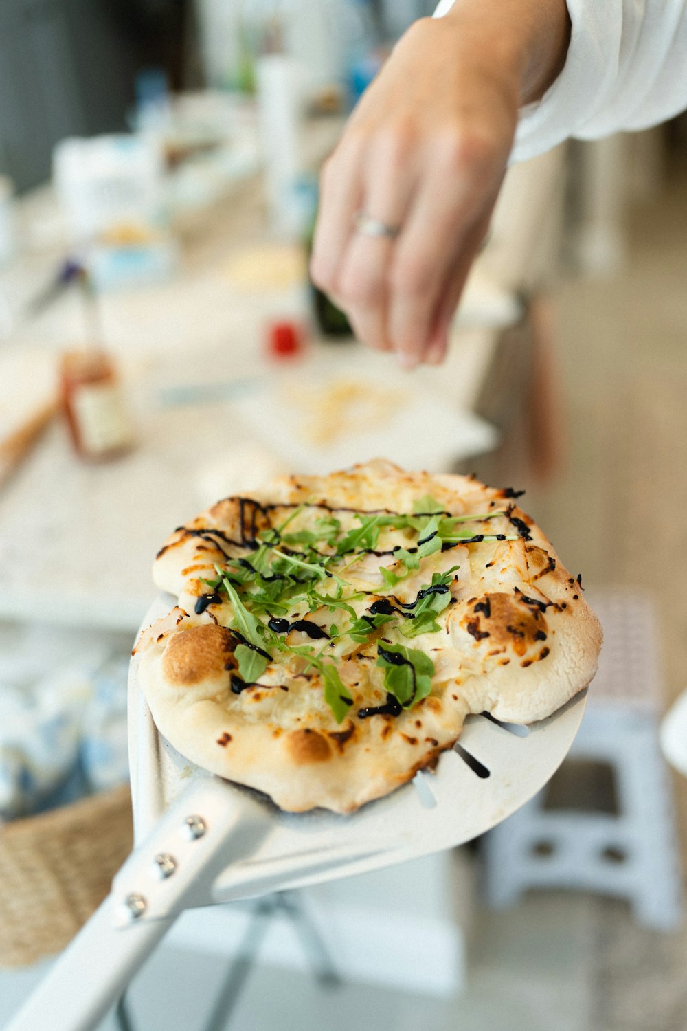 a person holding a pizza on a spatula