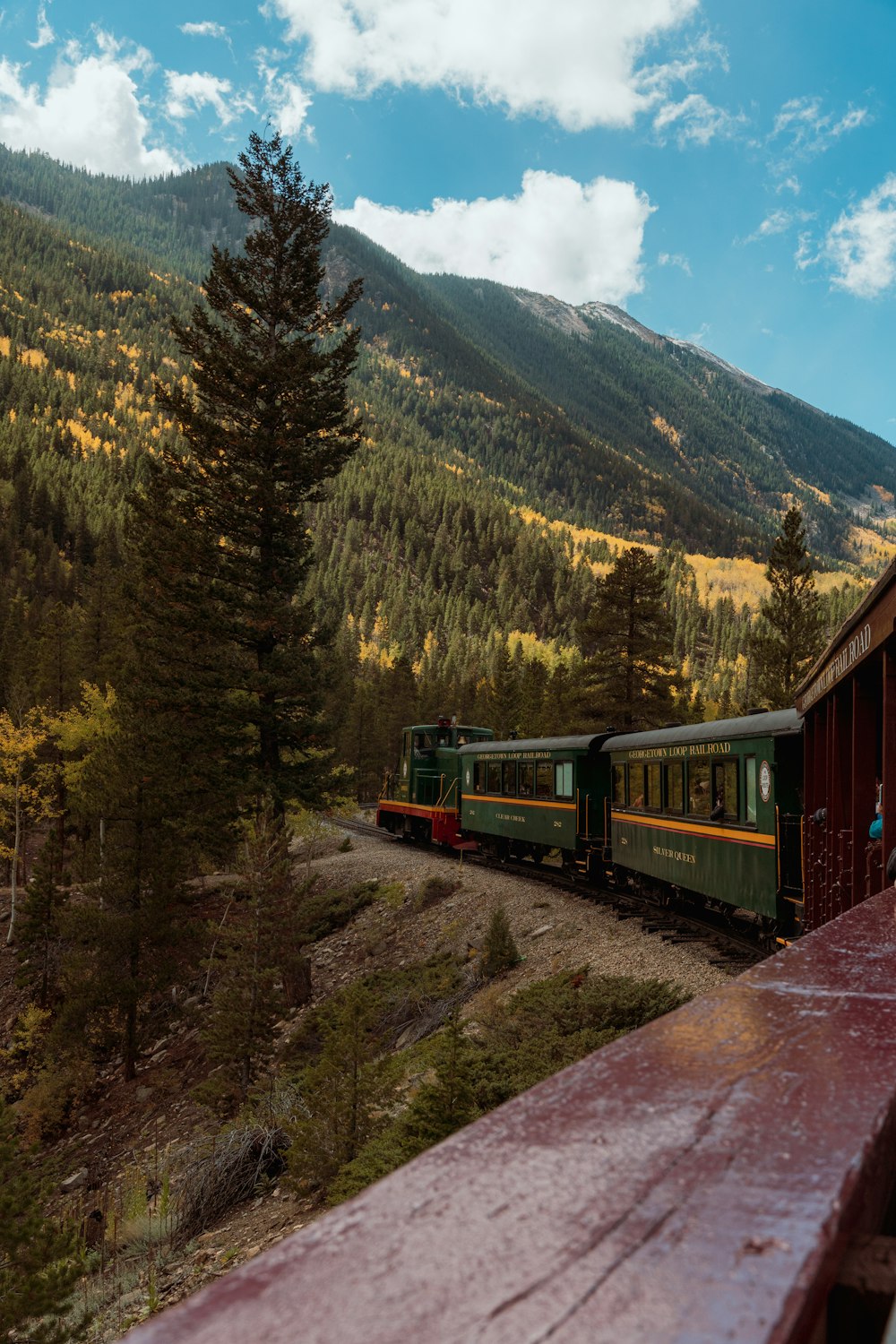 a train traveling down tracks next to a forest