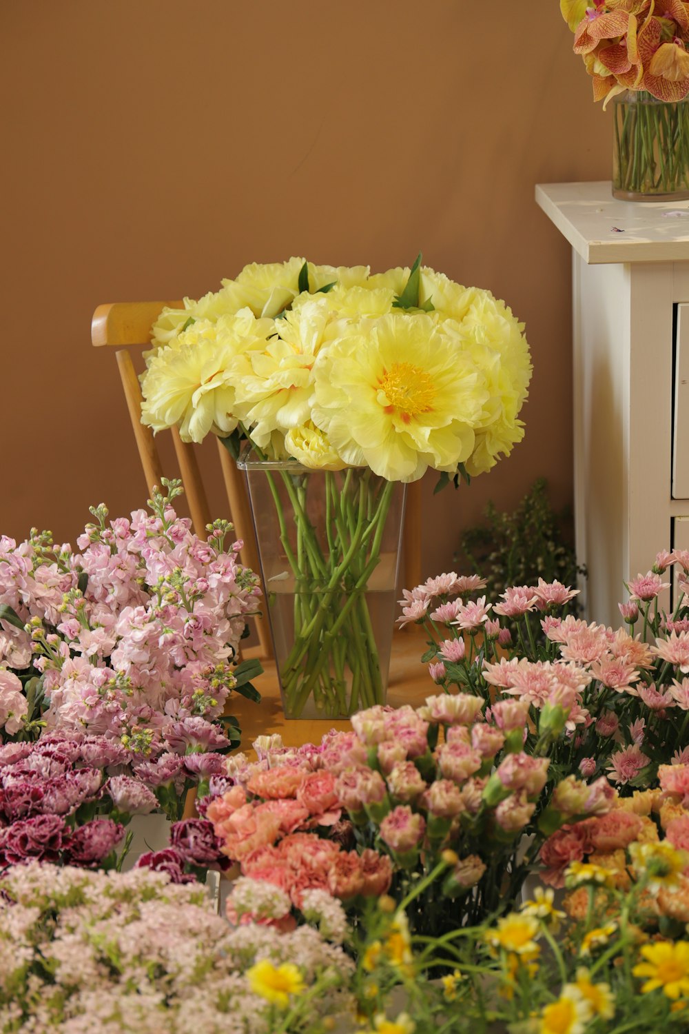 a vase filled with yellow and pink flowers