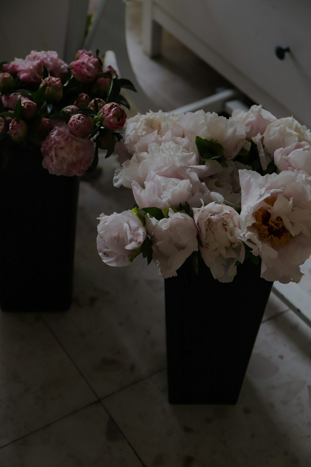 a couple of black vases filled with flowers