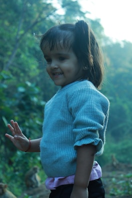 A local smiling child playing near the jungle path.