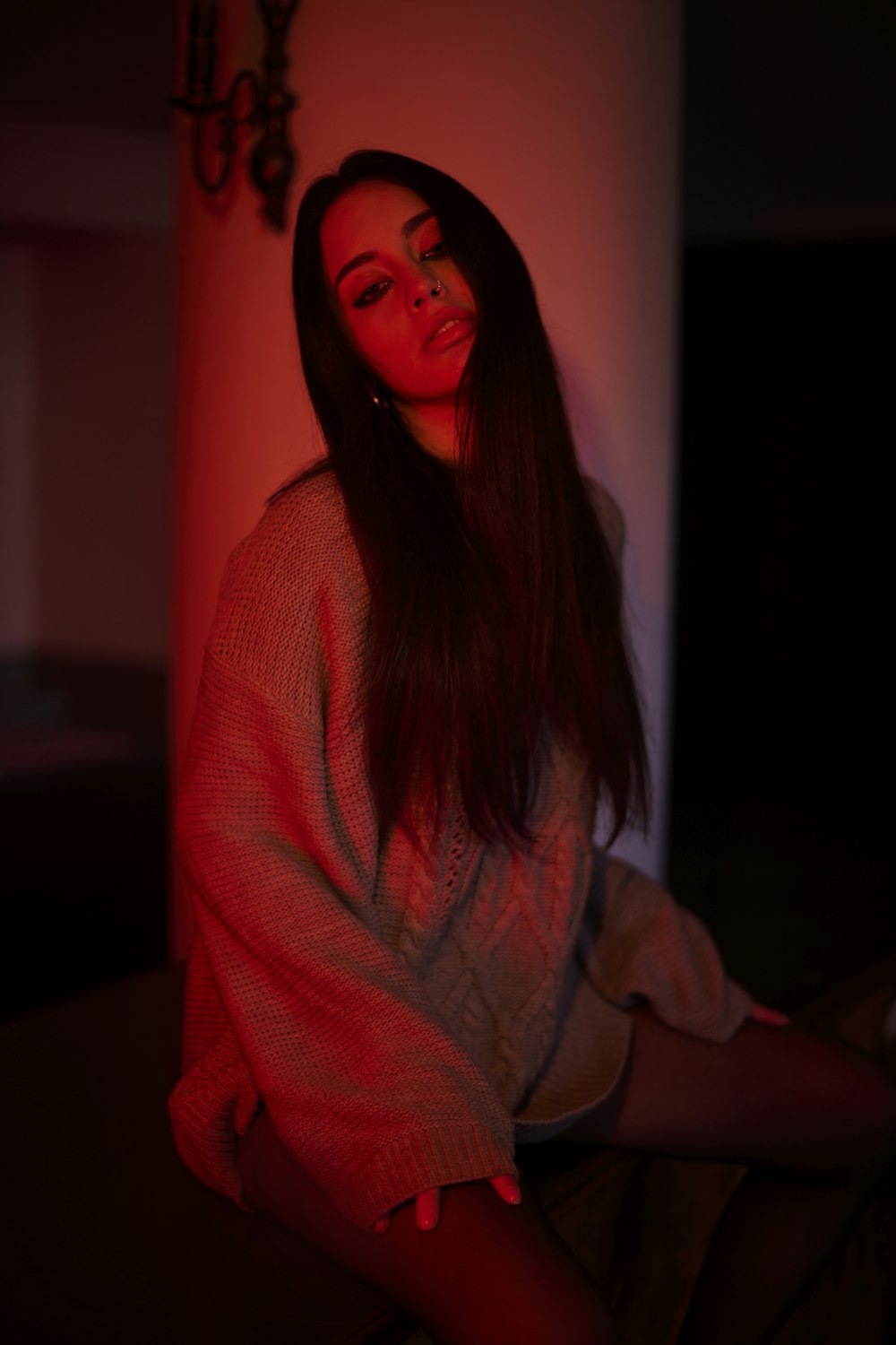 a woman sitting on the floor in a dark room