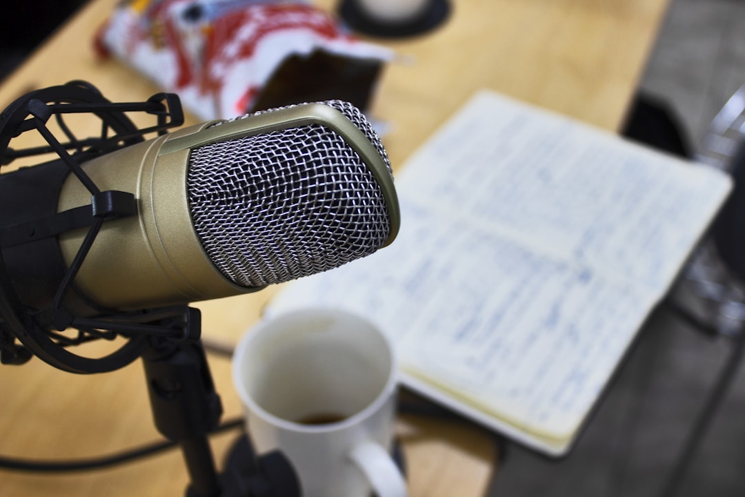 a microphone sitting on top of a wooden table, micrófono estudio de radio color dorado en primer plano sobre mesa de tra
