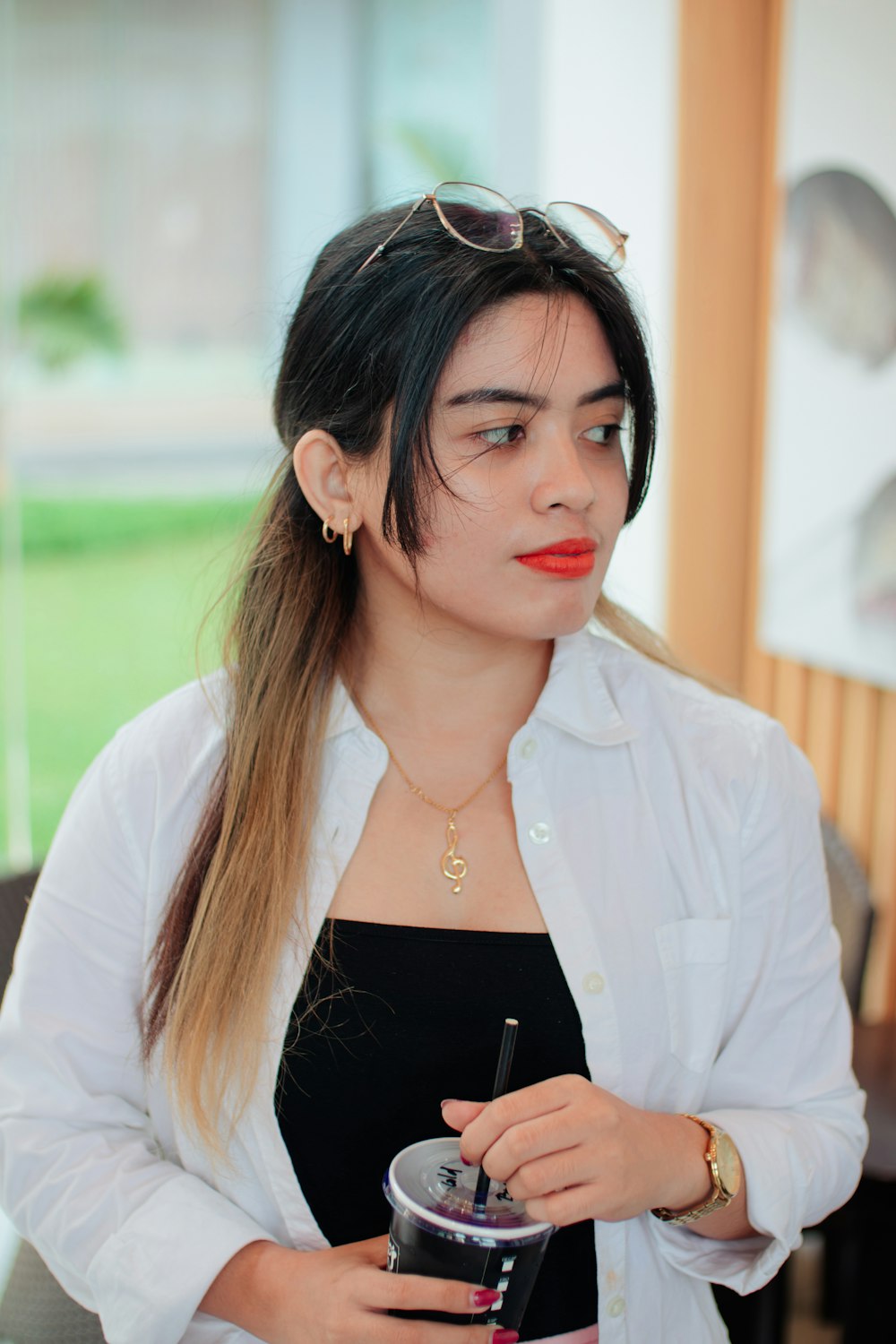 a woman with long hair is holding a drink