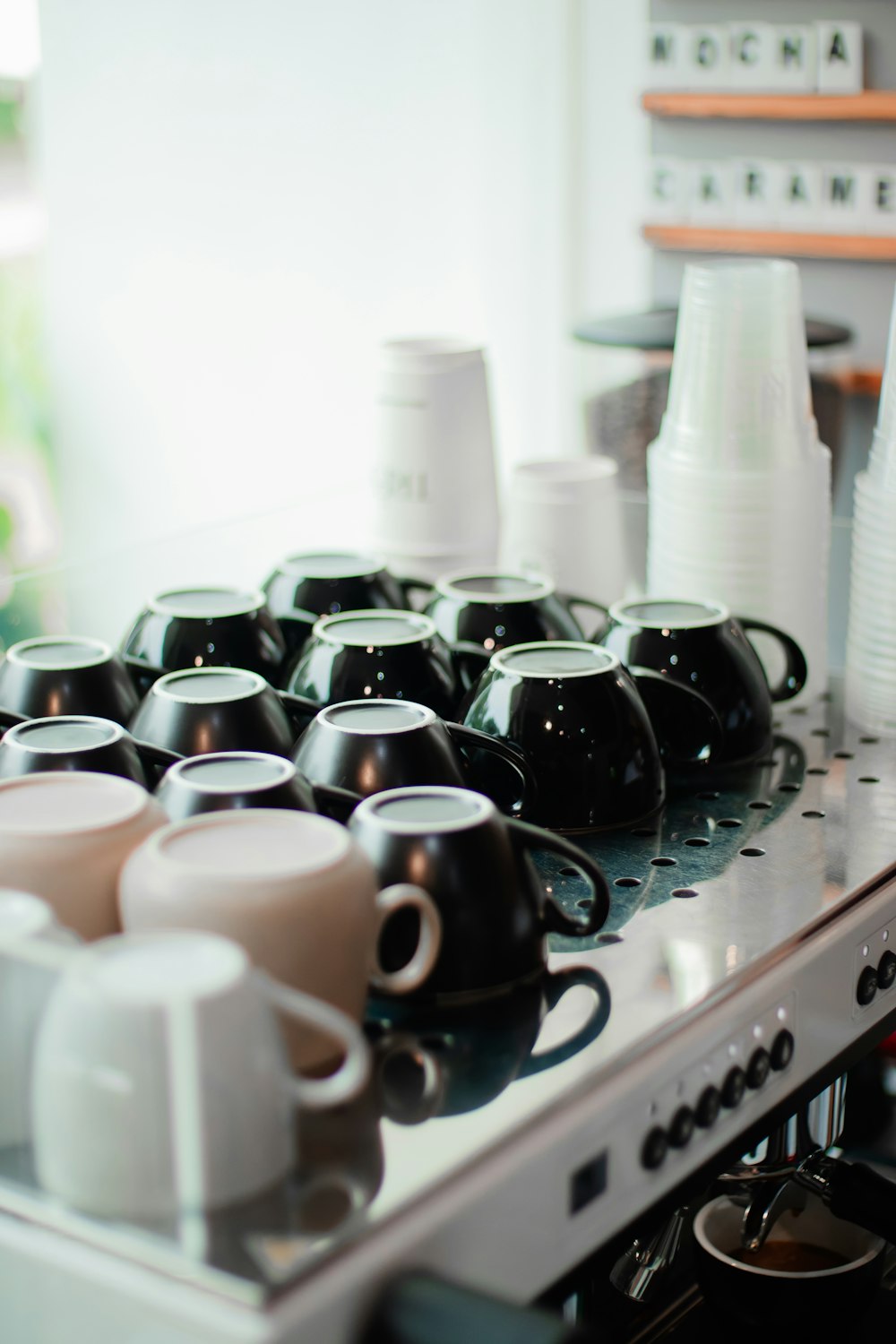 a bunch of coffee cups sitting on top of a stove