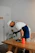 a man in an apron is sanding a wooden table