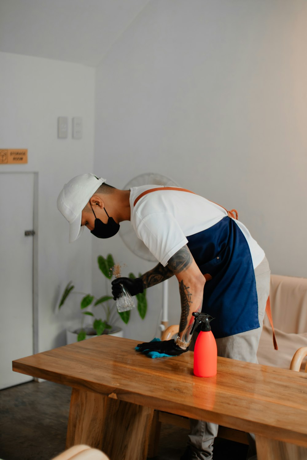 a man in an apron is sanding a wooden table