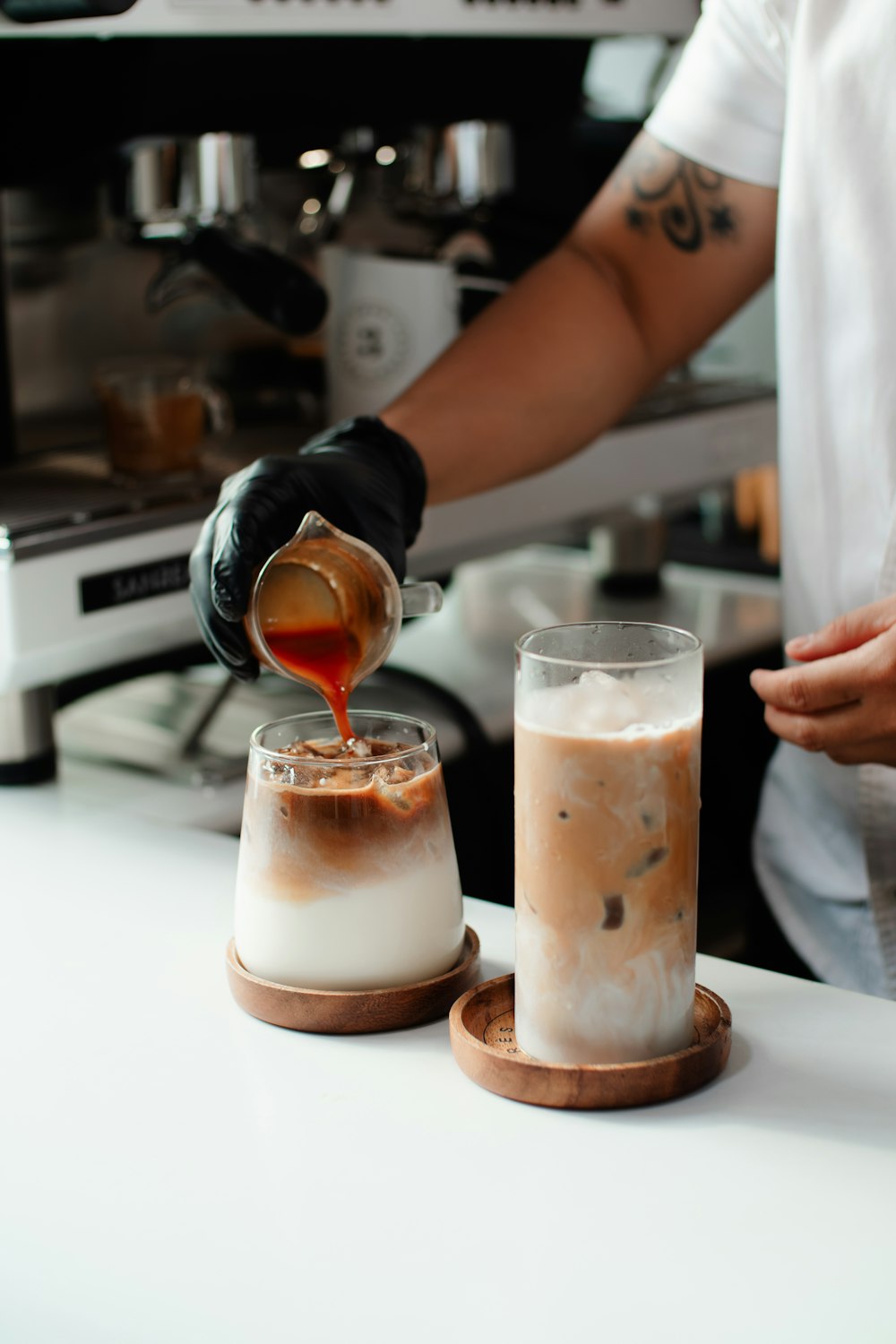 a person pouring something into a glass on a counter