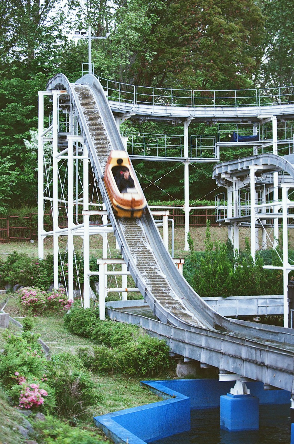 a person riding a water slide in a park