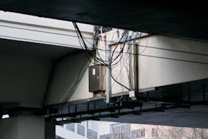 Technicians guiding fiber-optic cable installation through underground conduits in a residential neighborhood.