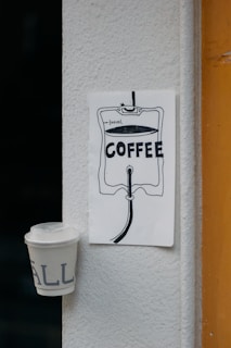 A storyboard sketch pinned on a wall next to a laptop and coffee cup.