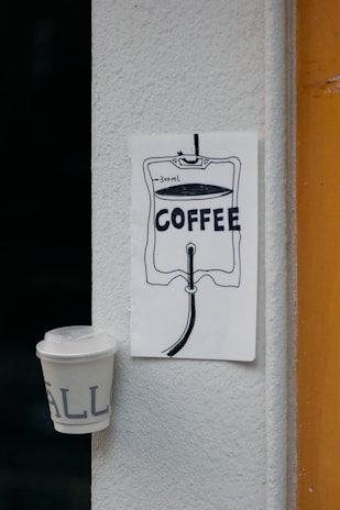 A storyboard sketch pinned on a wall next to a laptop and coffee cup.