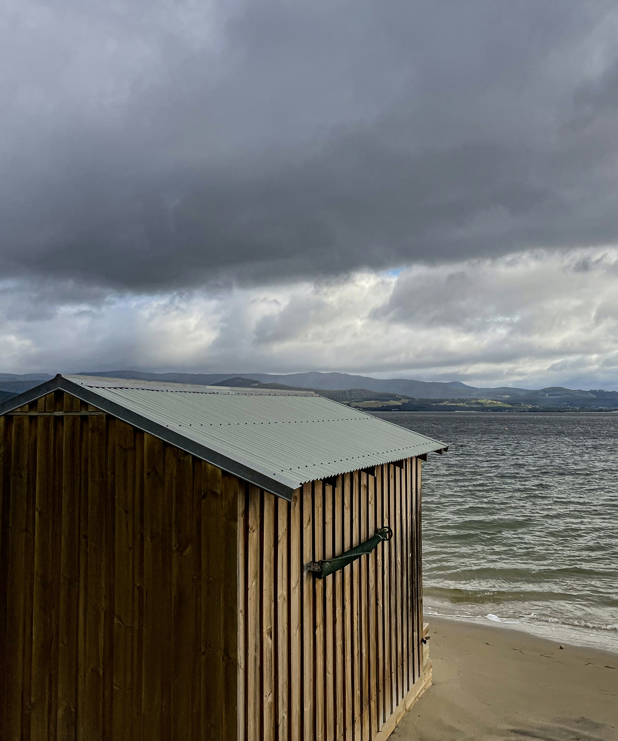 a beach hut sitting on top of a sandy beach
