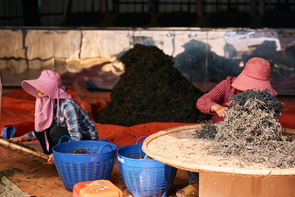 two women working in a factory with buckets of dirt