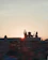 A serene sunset view of the Vishnupad Temple with pilgrims performing rituals by the Falgu River.