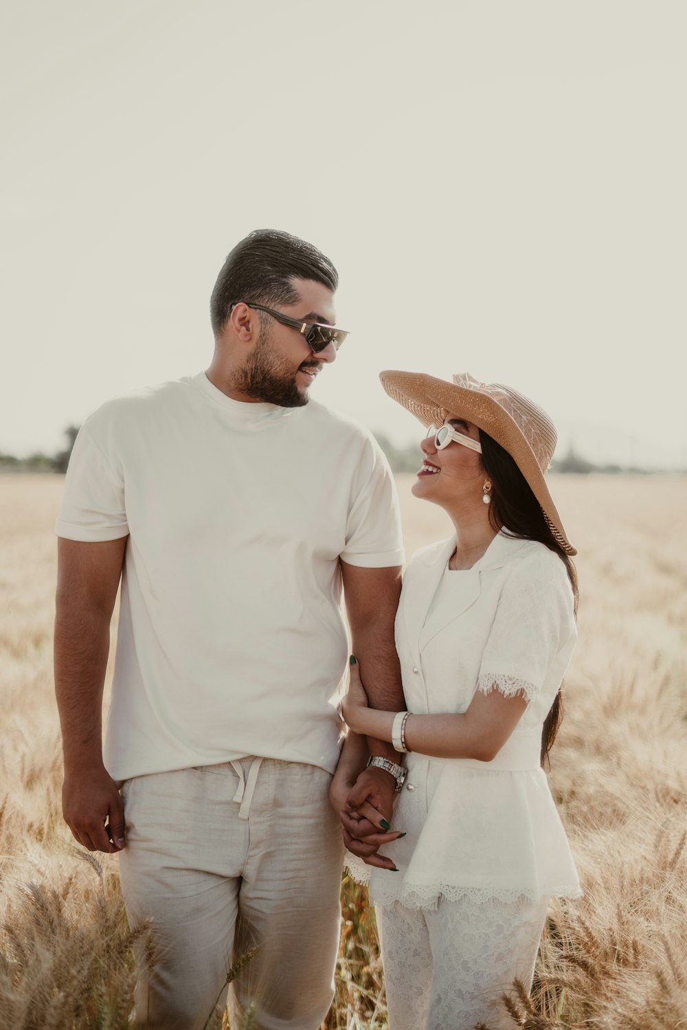 a man and a woman standing in a wheat field