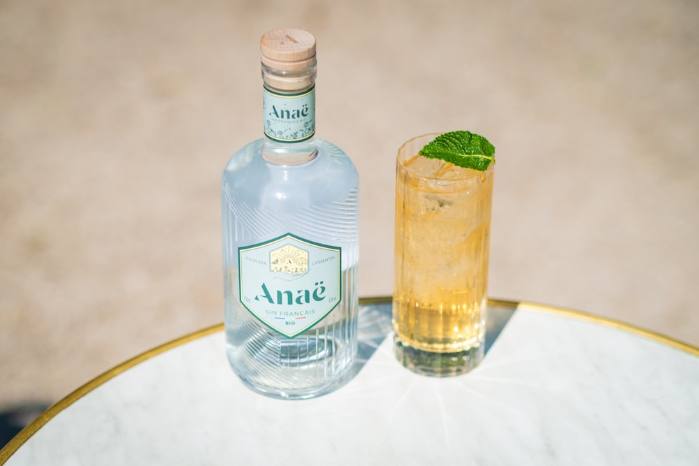 a bottle and a glass sitting on a table