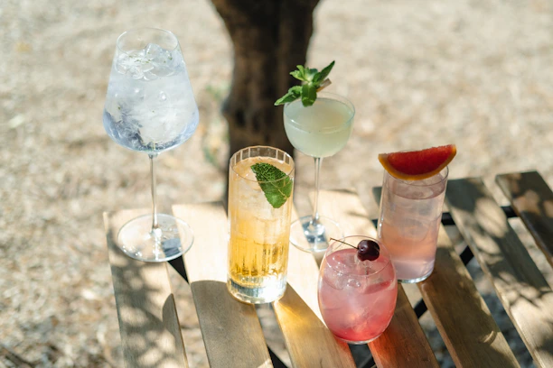 A stylish bar cart set up with drinks and glasses on a wooden deck.