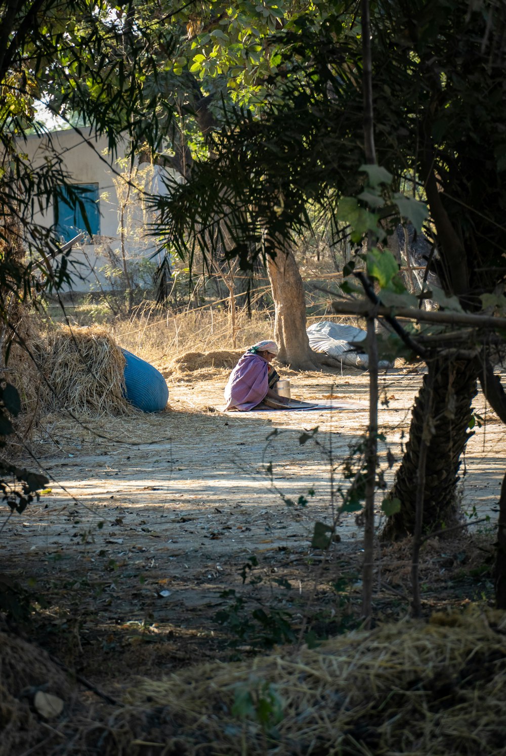 a person laying on the ground next to a pile of hay