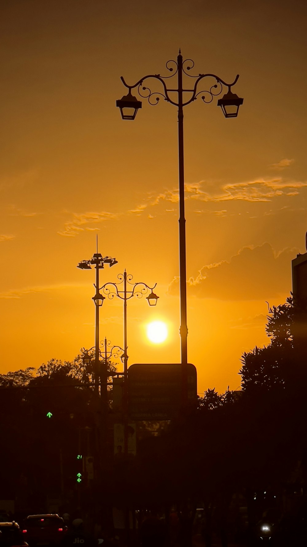 un lampione con il sole che tramonta sullo sfondo