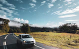 An outstation cab crossing a scenic rural road with fields stretching into the horizon.
