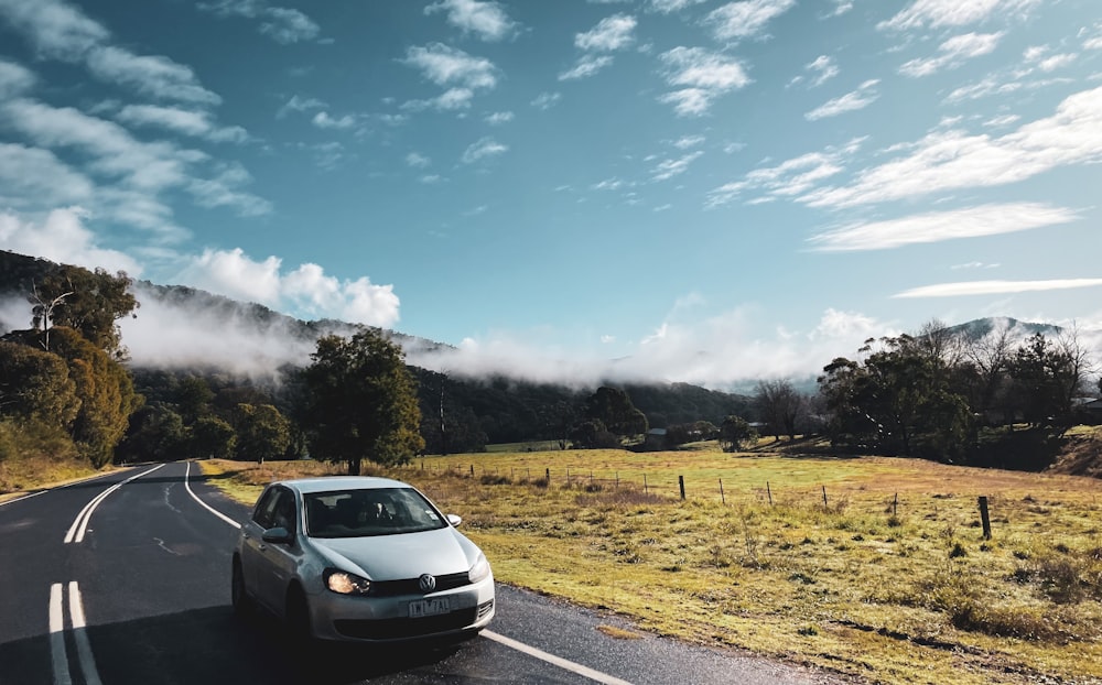 a car driving down the road in the mountains