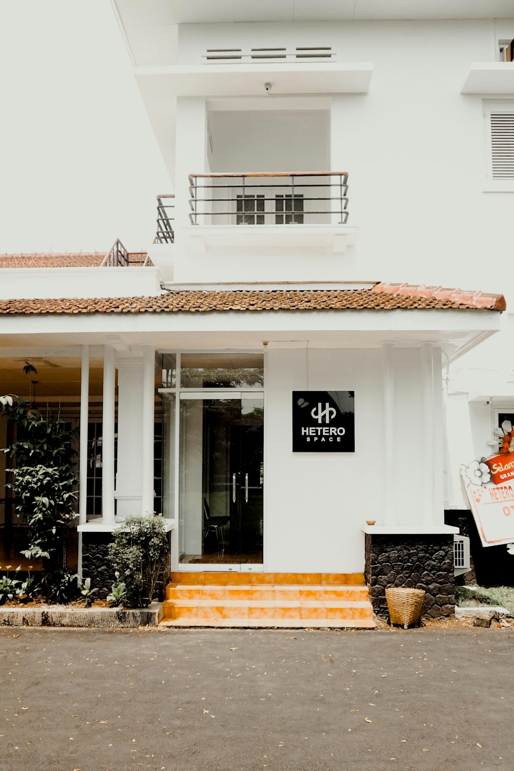 the front of a white building with a sign on it