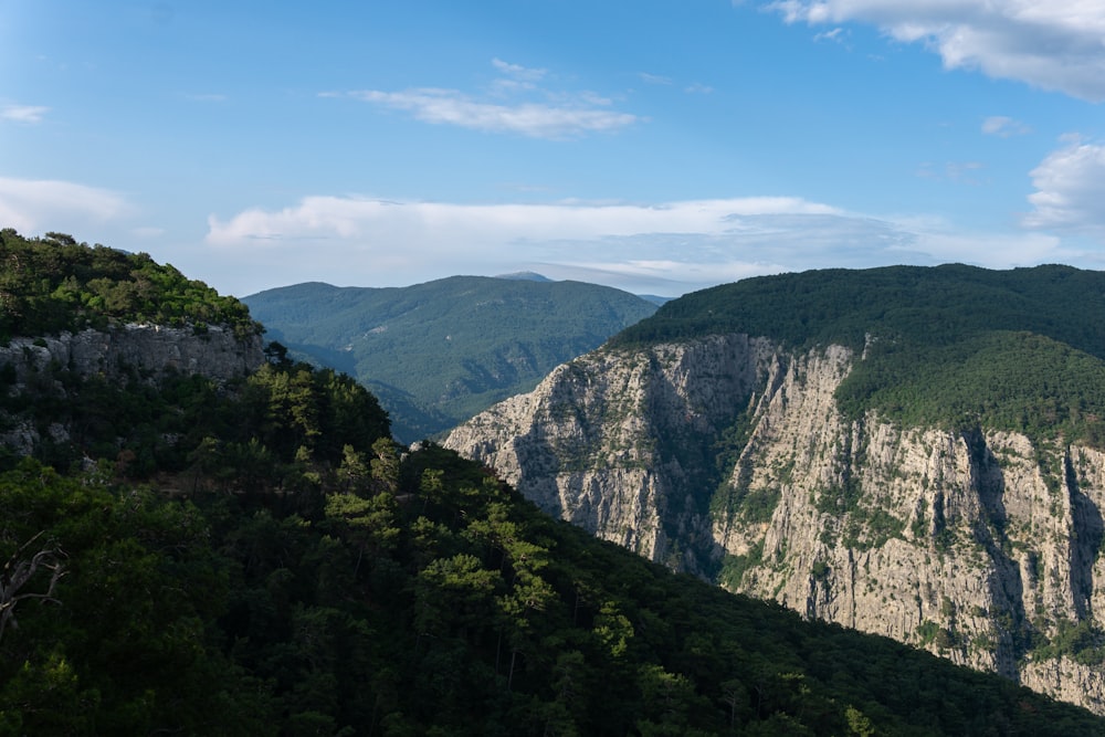 a view of a mountain range with trees and mountains in the background