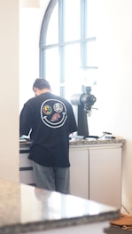 a man standing in front of a counter in a kitchen