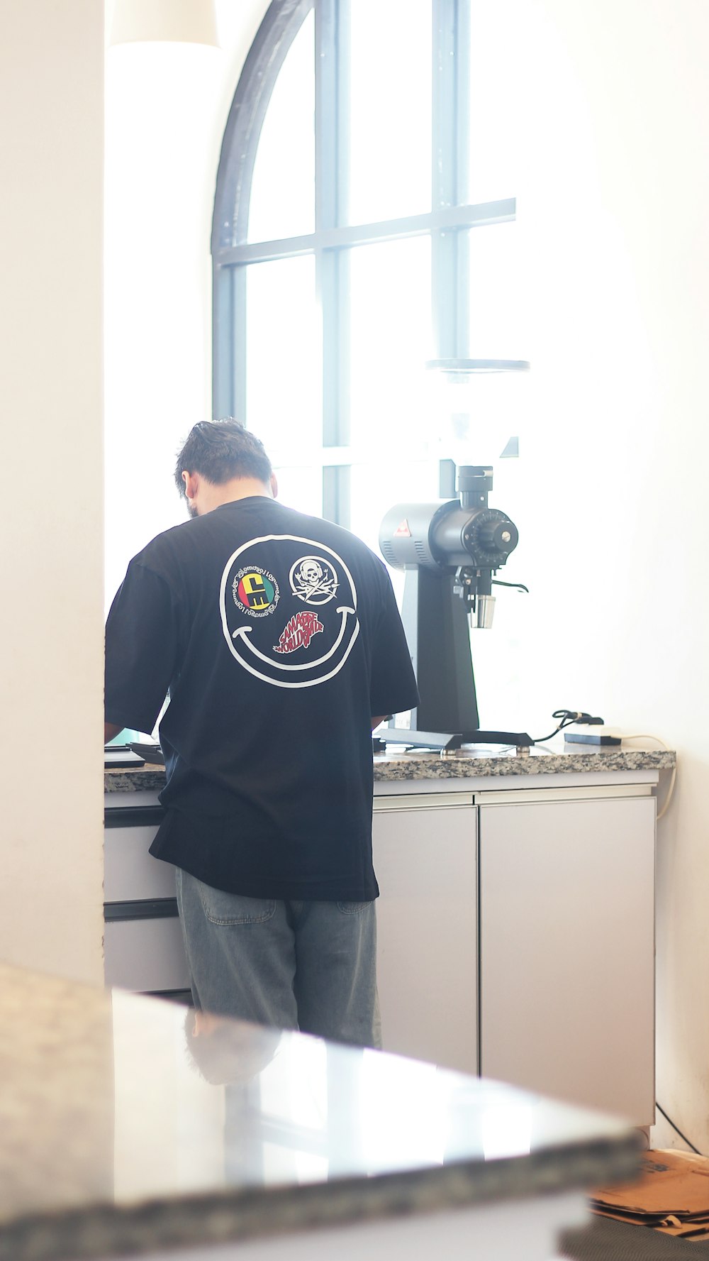 a man standing in front of a counter in a kitchen