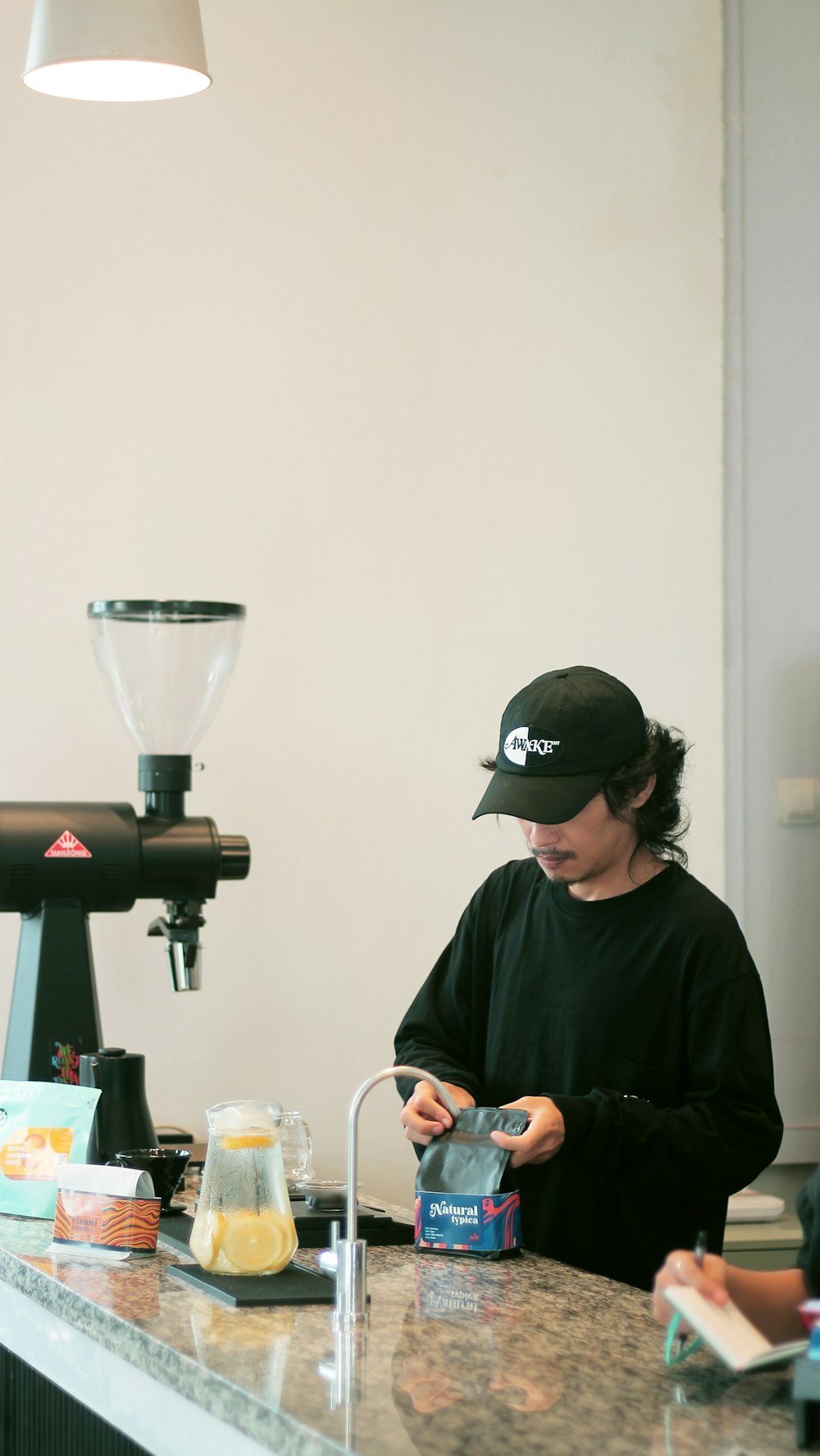 a person standing at a counter with a blender