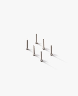 Seven silver screws are neatly arranged in a hexagonal pattern on a white surface, casting soft shadows.