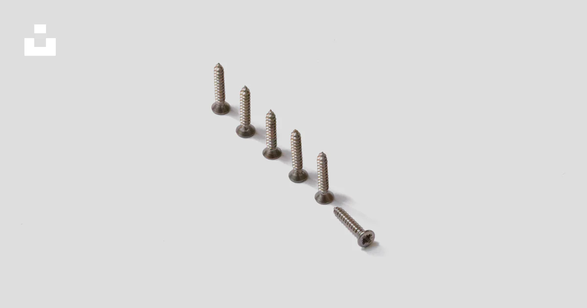 Screw Rows Design A row of screws sitting on top of a white surface photo – Free Uk Image ...