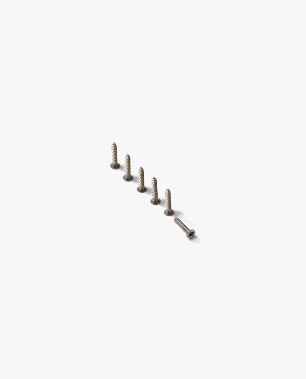 a row of screws sitting on top of a white surface